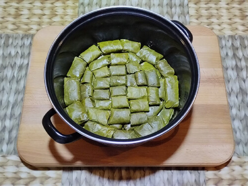 Таким способом завернуть все листья, аккуратно укладывая в кастрюлю. В кастрюле должно остаться место для воды, так как Долма во время варки увеличивается в размере, и вода может выкипеть.