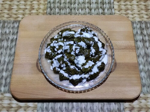 Подавать долму можно с соусом из мацони, сметаны, йогурта, заправленным чесноком и зеленью.