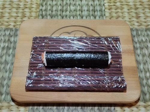 Свернуть ролл и слегка уплотнить его, сжав руками.