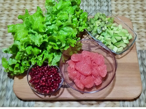 Листья салата помыть, обсушить. Гранат почистить, грейпфрут, киви и авокадо очистить, нарезать кубиком. При чистке грейпфрута выделяется много сока, он пойдёт в заправку для салата.