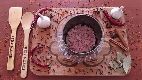 Установить кулинарное кольцо на плоскую тарелку. Выложить на дно первый слой копченой курицы.