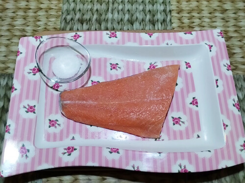 Соединить соль с сахаром. Половиной смеси натереть рыбу с одной стороны.